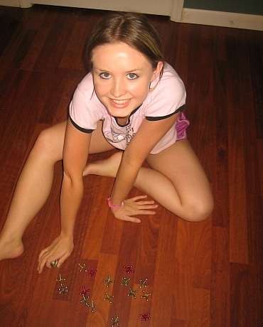 Kitty sits on the floor in her bedroom