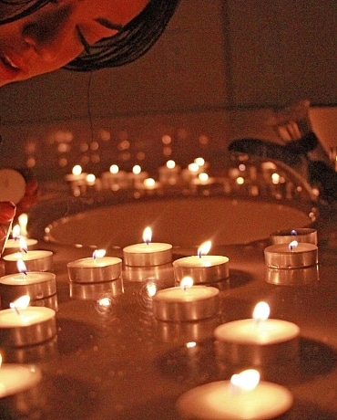 Layla puts out candles on her bath counter top