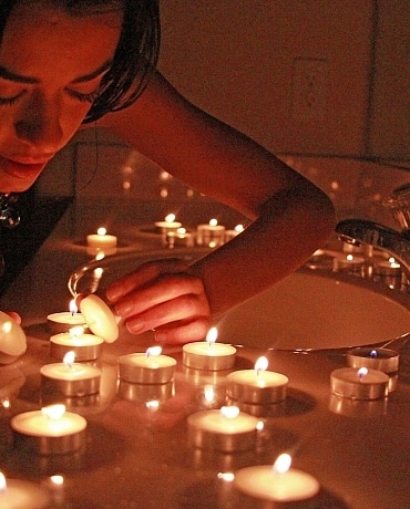 Layla puts out candles on her bath counter top